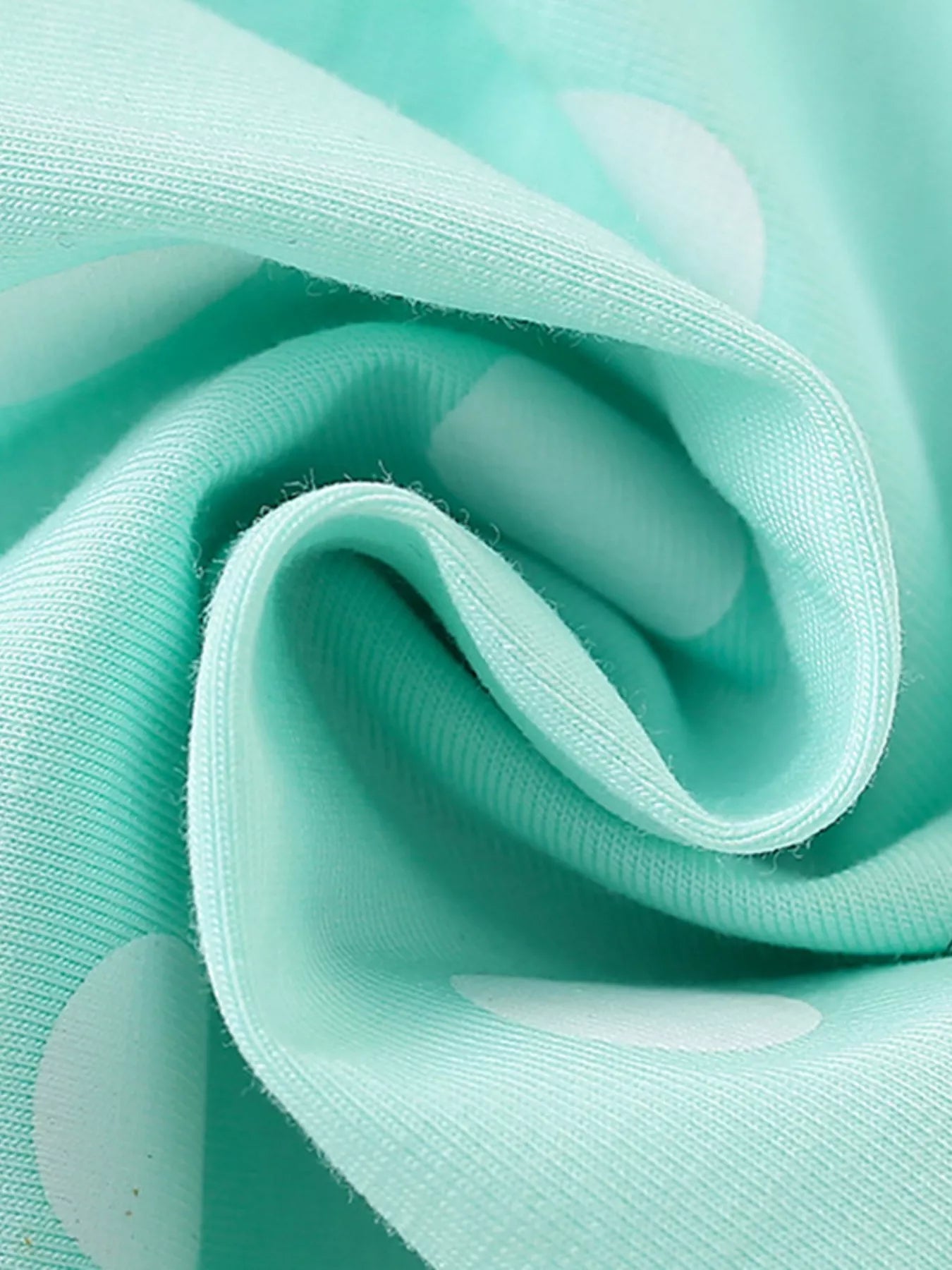 Toddler wearing mint green polka dot dress with popsicle pocket detail