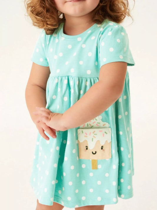 Toddler wearing mint green polka dot dress with popsicle pocket detail