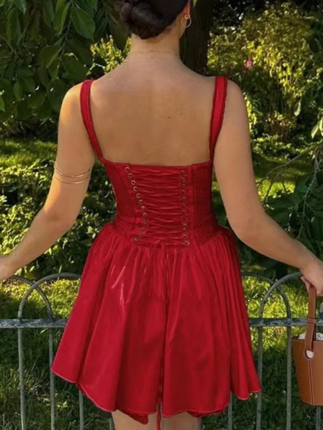Woman modeling a red Sweetheart Corset Mini Dress with lace-up front, lace accents, and a flared mini skirt, styled against a white background.