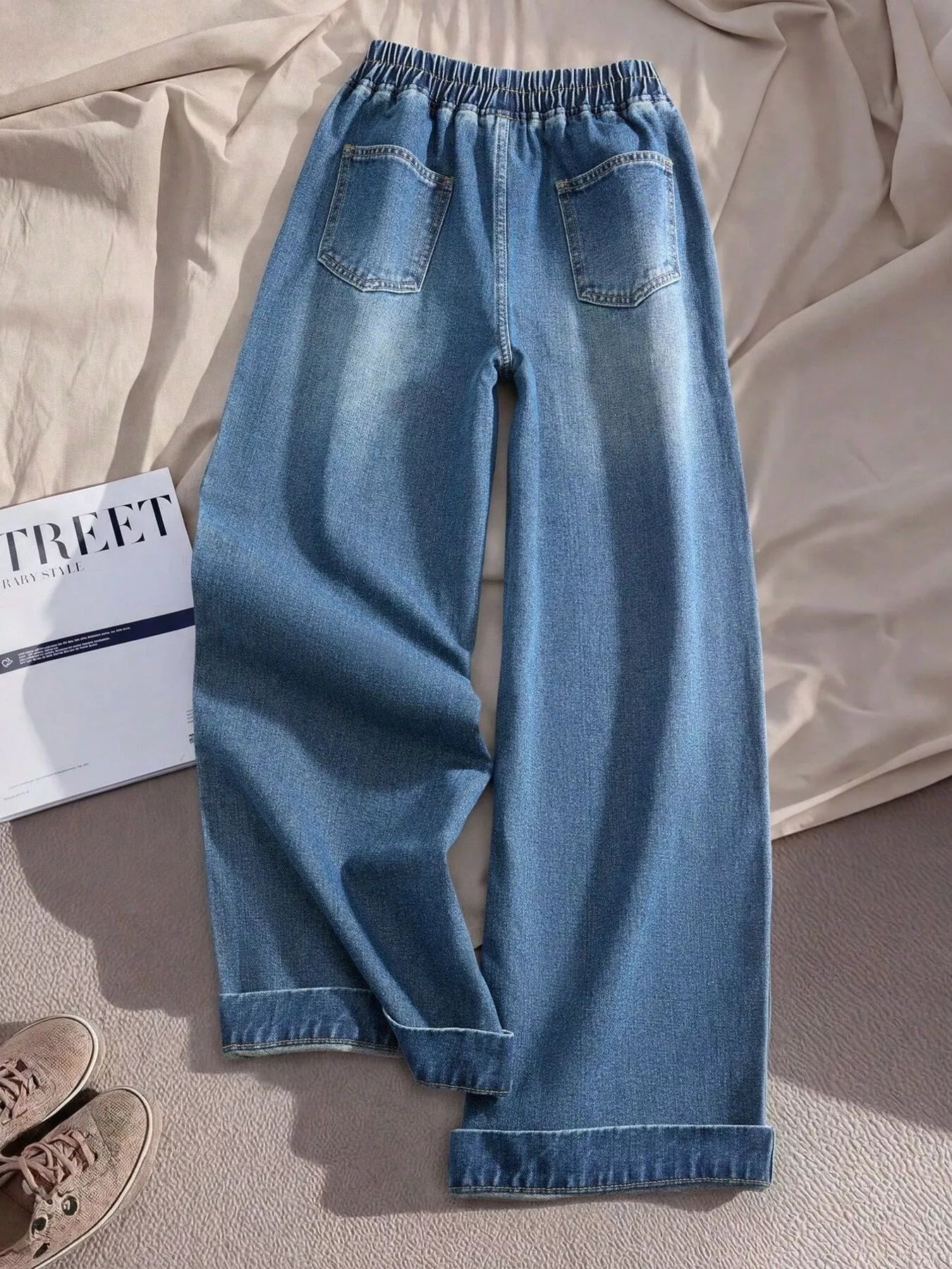 Relaxed denim pants with embroidered red and white heart details along the side panels, elastic waistband, and cuffed hems.