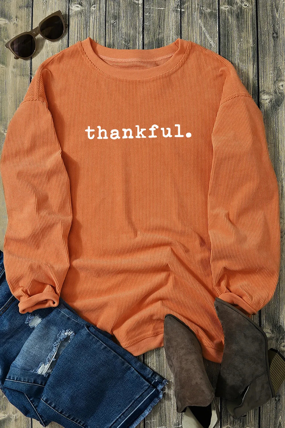 An orange corduroy pullover with the word “thankful.” printed across the chest — cozy fall sweatshirt from A Whimsical Affair.