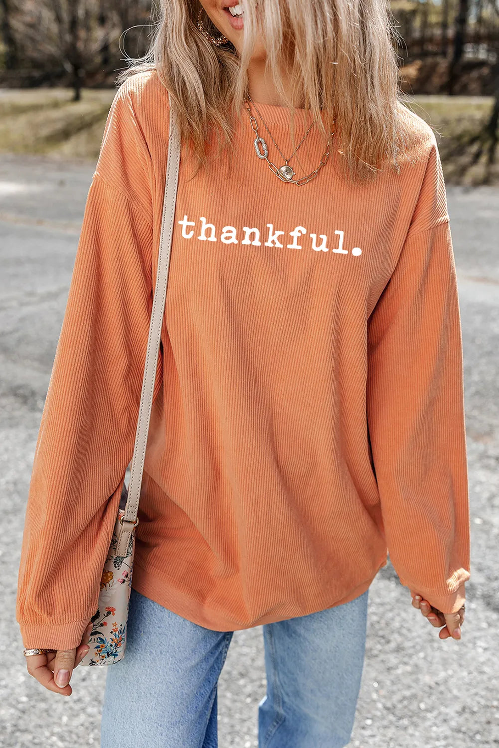 Woman wearing an orange corduroy pullover with the word “thankful.” printed across the chest — cozy fall sweatshirt from A Whimsical Affair.