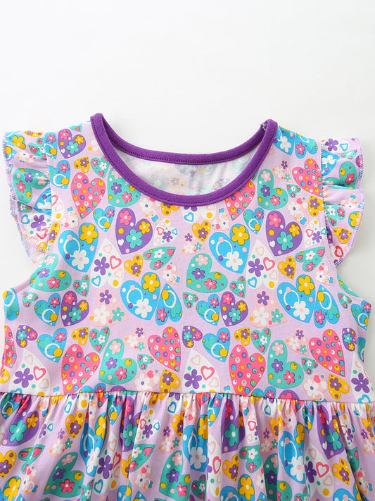 Girls cotton dress with colorful paisley floral print, purple trim, flutter sleeves, and heart-shaped front pockets.