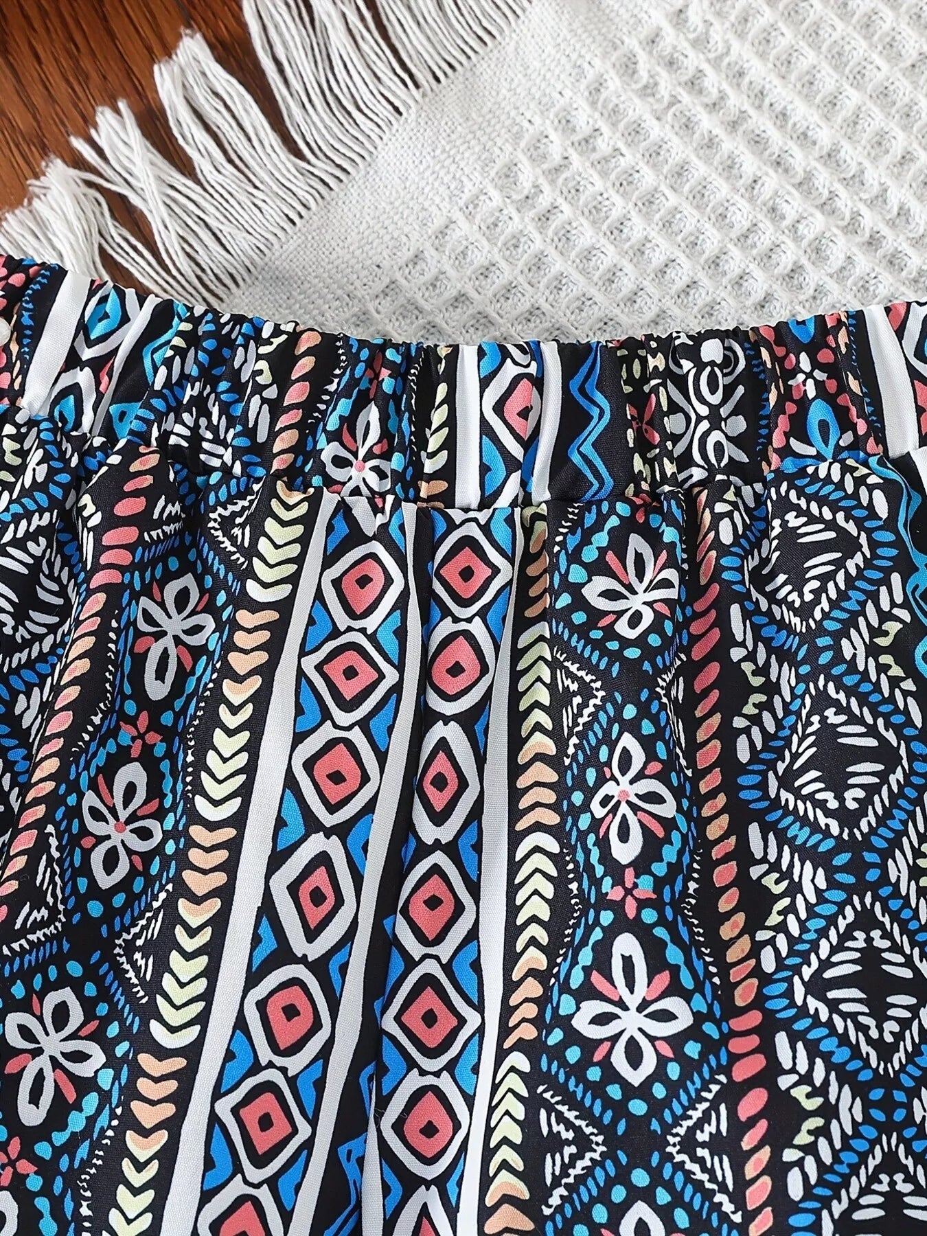 Children’s two-piece boho outfit with tassel crop top, printed wide-leg pants, pockets, and colorful summer styling.