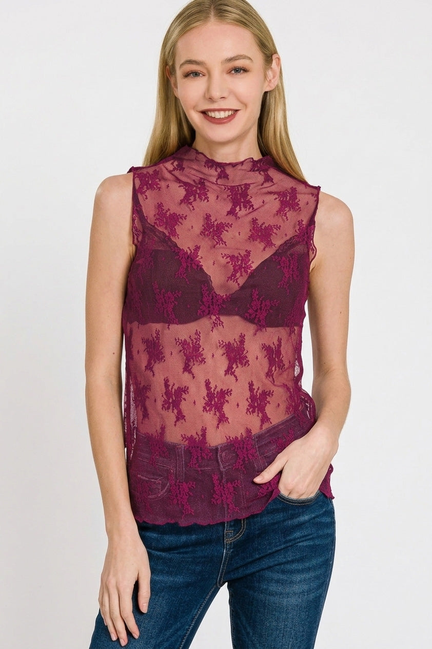 Woman wearing a sheer floral lace mock neck sleeveless tank in rich berry tone