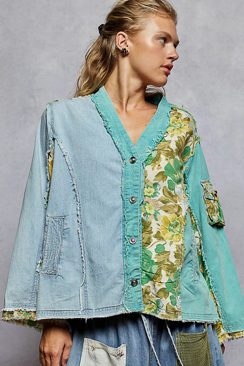 Woman wearing a green and blue patchwork button-up boho top with floral panels and raw frayed edges