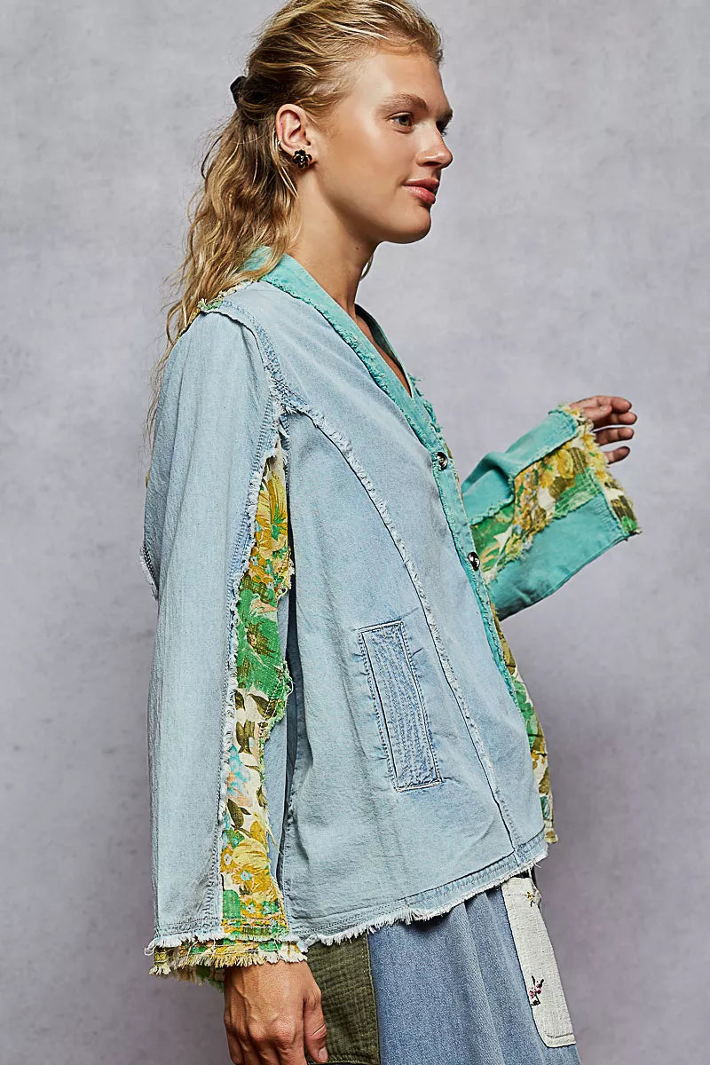Woman wearing a green and blue patchwork button-up boho top with floral panels and raw frayed edges