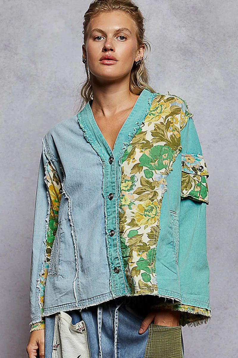 Woman wearing a green and blue patchwork button-up boho top with floral panels and raw frayed edges