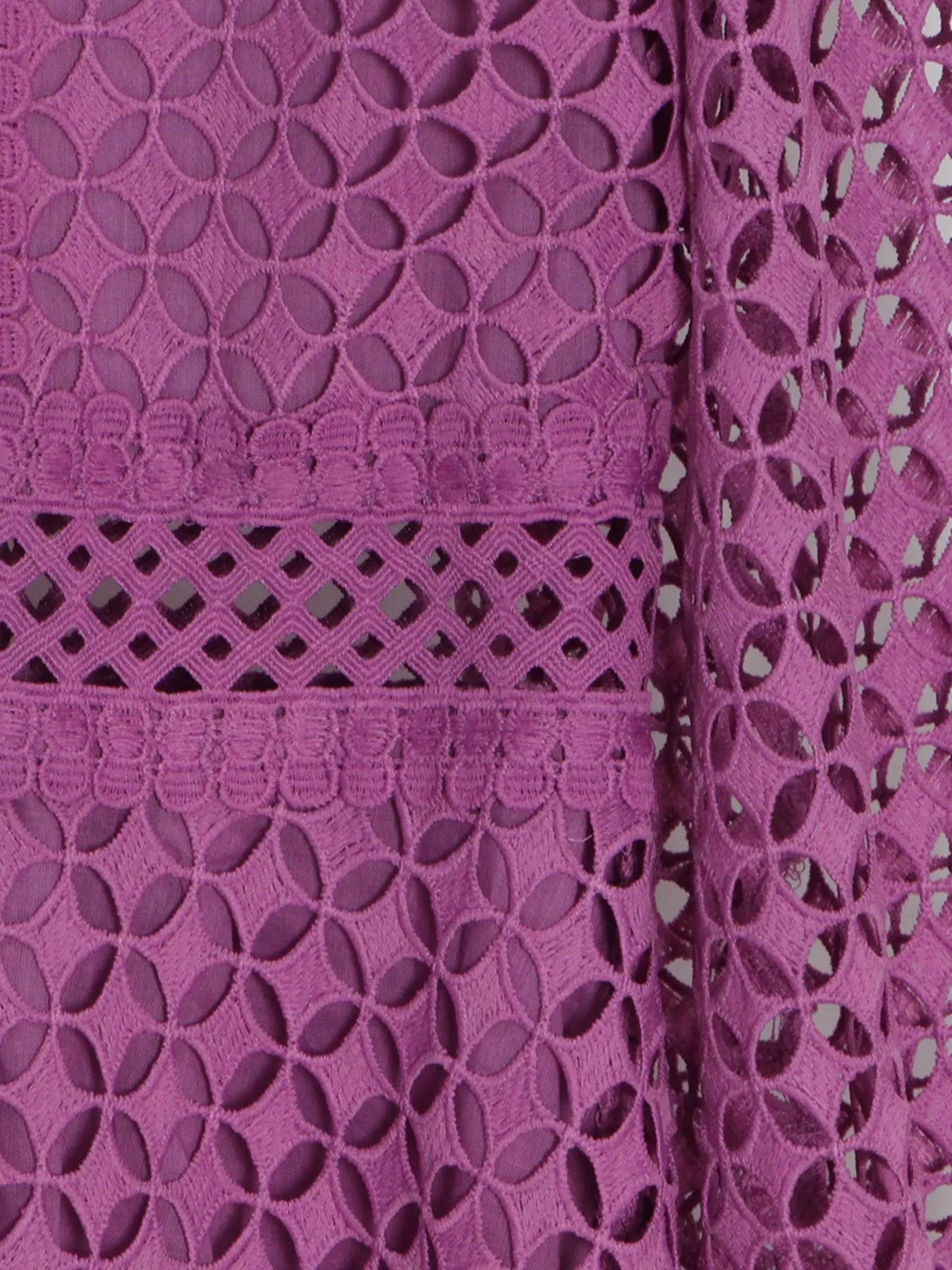 Model wearing the Violet Lace Cutout Midi Dress with long sheer balloon sleeves, high neckline, and geometric lace design, styled with white strappy heels.