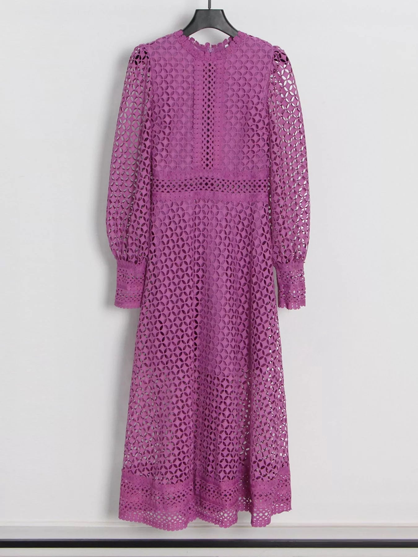 Model wearing the Violet Lace Cutout Midi Dress with long sheer balloon sleeves, high neckline, and geometric lace design, styled with white strappy heels.