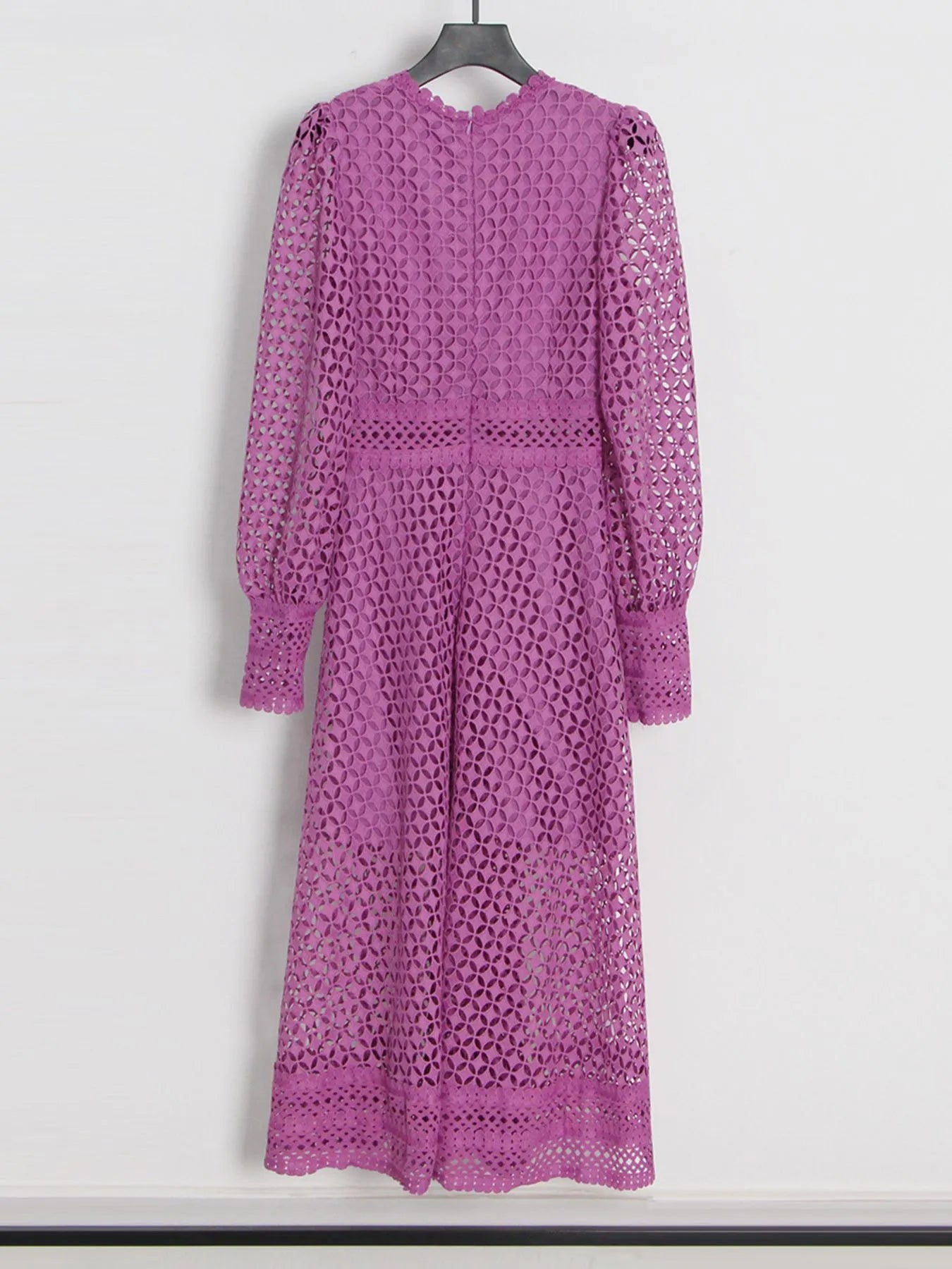 Model wearing the Violet Lace Cutout Midi Dress with long sheer balloon sleeves, high neckline, and geometric lace design, styled with white strappy heels.