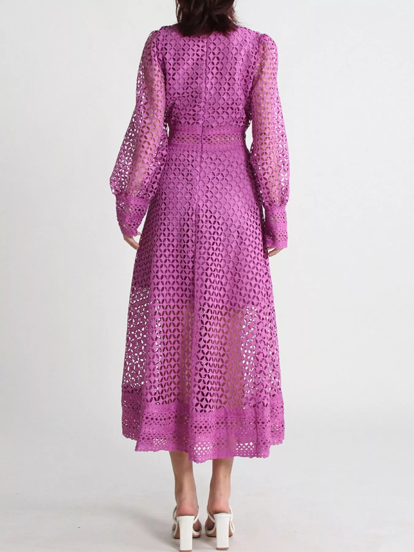 Model wearing the Violet Lace Cutout Midi Dress with long sheer balloon sleeves, high neckline, and geometric lace design, styled with white strappy heels.
