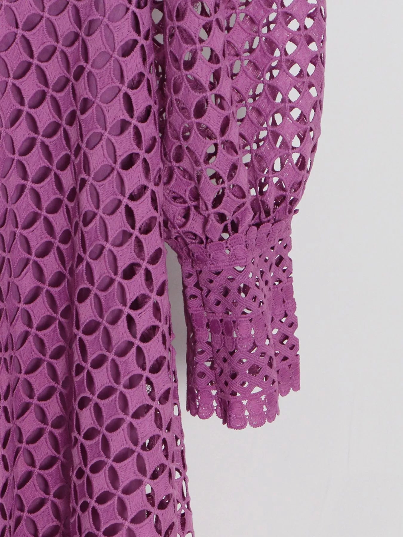 Model wearing the Violet Lace Cutout Midi Dress with long sheer balloon sleeves, high neckline, and geometric lace design, styled with white strappy heels.