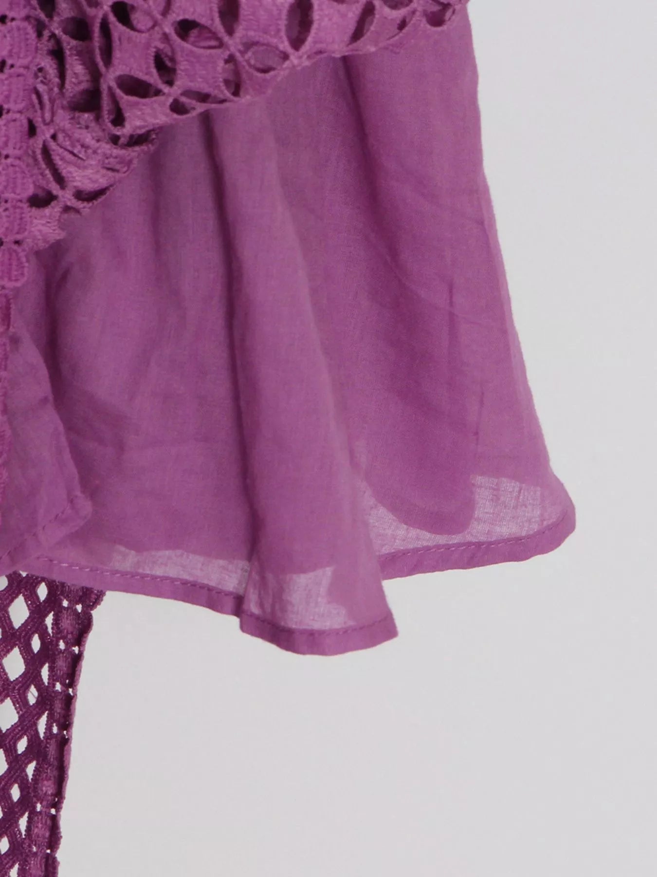 Model wearing the Violet Lace Cutout Midi Dress with long sheer balloon sleeves, high neckline, and geometric lace design, styled with white strappy heels.