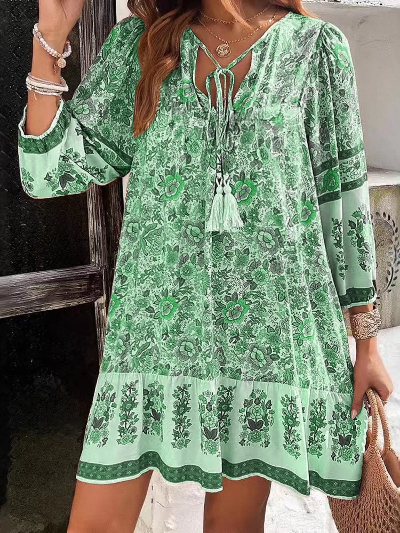 Boho floral tunic dress with long sleeves, a tie neckline, and mixed floral border print.