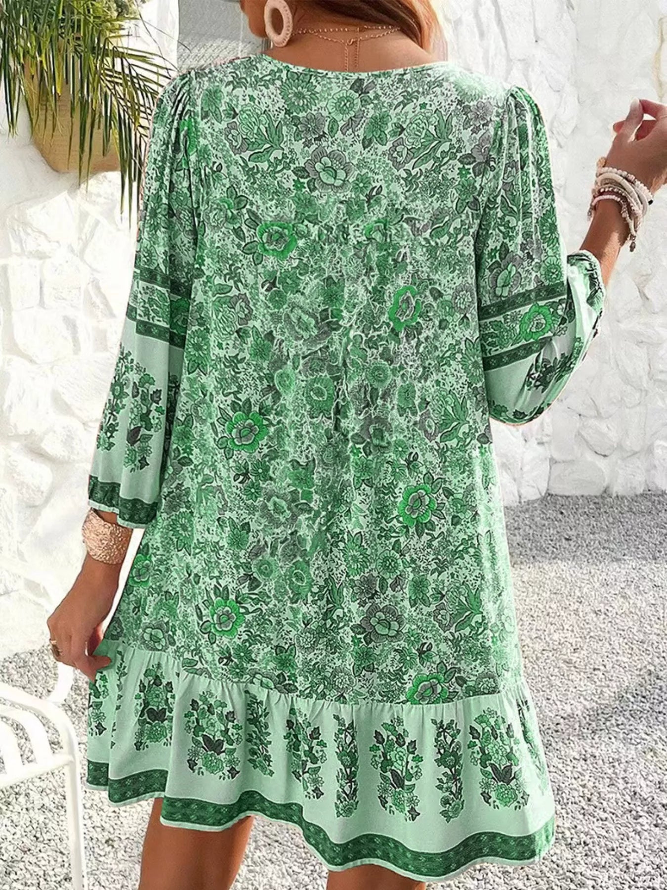 Boho floral tunic dress with long sleeves, a tie neckline, and mixed floral border print.