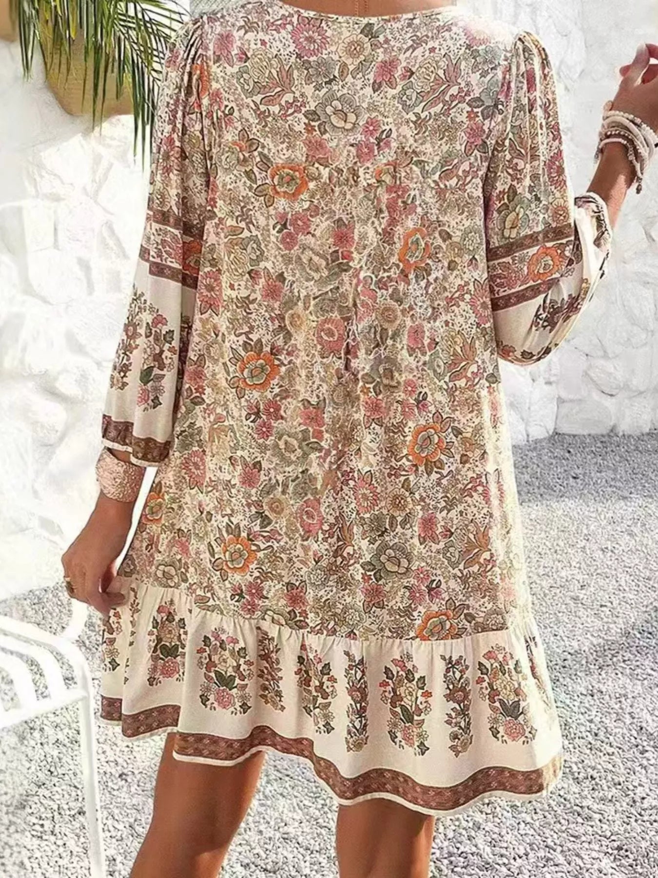 Boho floral tunic dress with long sleeves, a tie neckline, and mixed floral border print.