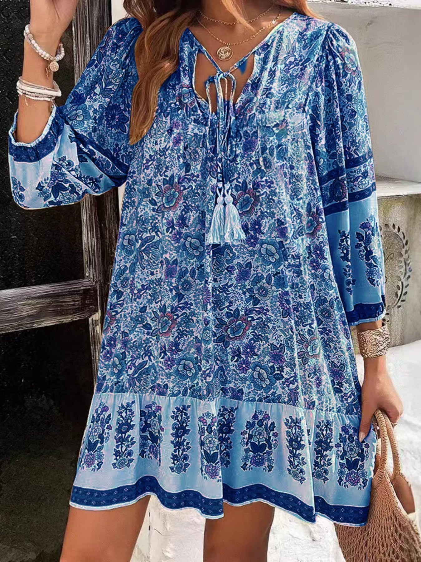 Boho floral tunic dress with long sleeves, a tie neckline, and mixed floral border print.