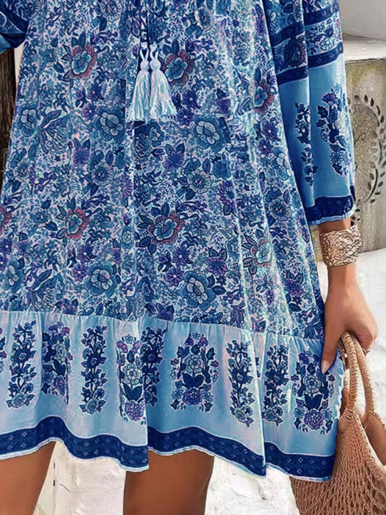 Boho floral tunic dress with long sleeves, a tie neckline, and mixed floral border print.