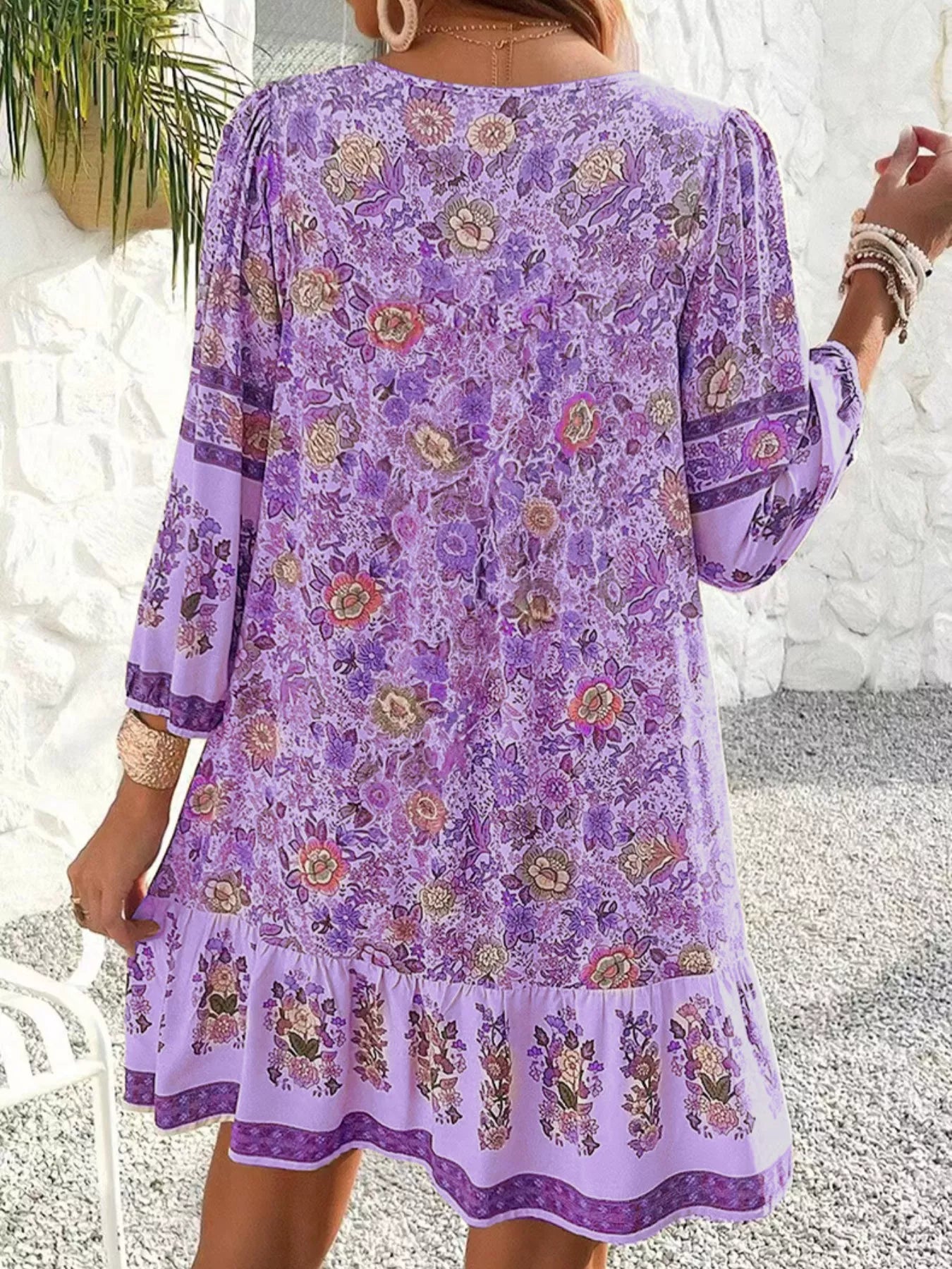 Boho floral tunic dress with long sleeves, a tie neckline, and mixed floral border print.