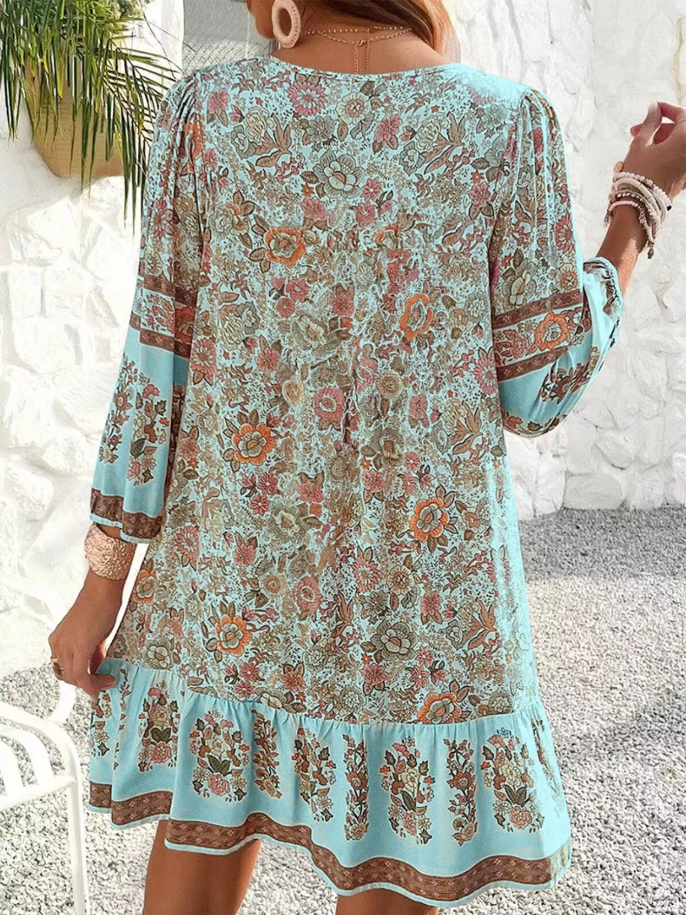 Boho floral tunic dress with long sleeves, a tie neckline, and mixed floral border print.