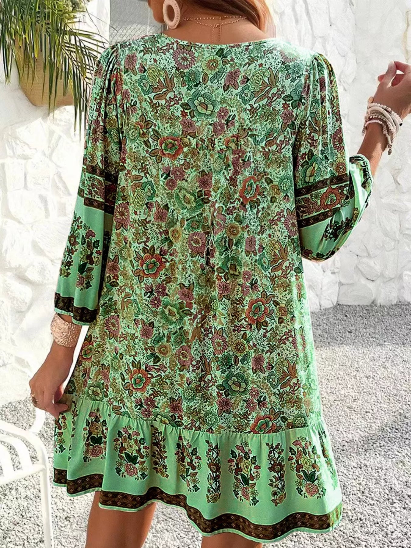 Boho floral tunic dress with long sleeves, a tie neckline, and mixed floral border print.