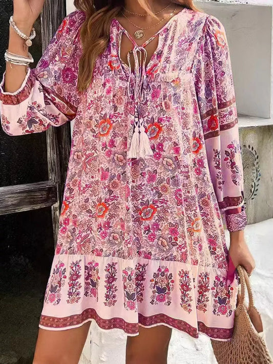 Boho floral tunic dress with long sleeves, a tie neckline, and mixed floral border print.