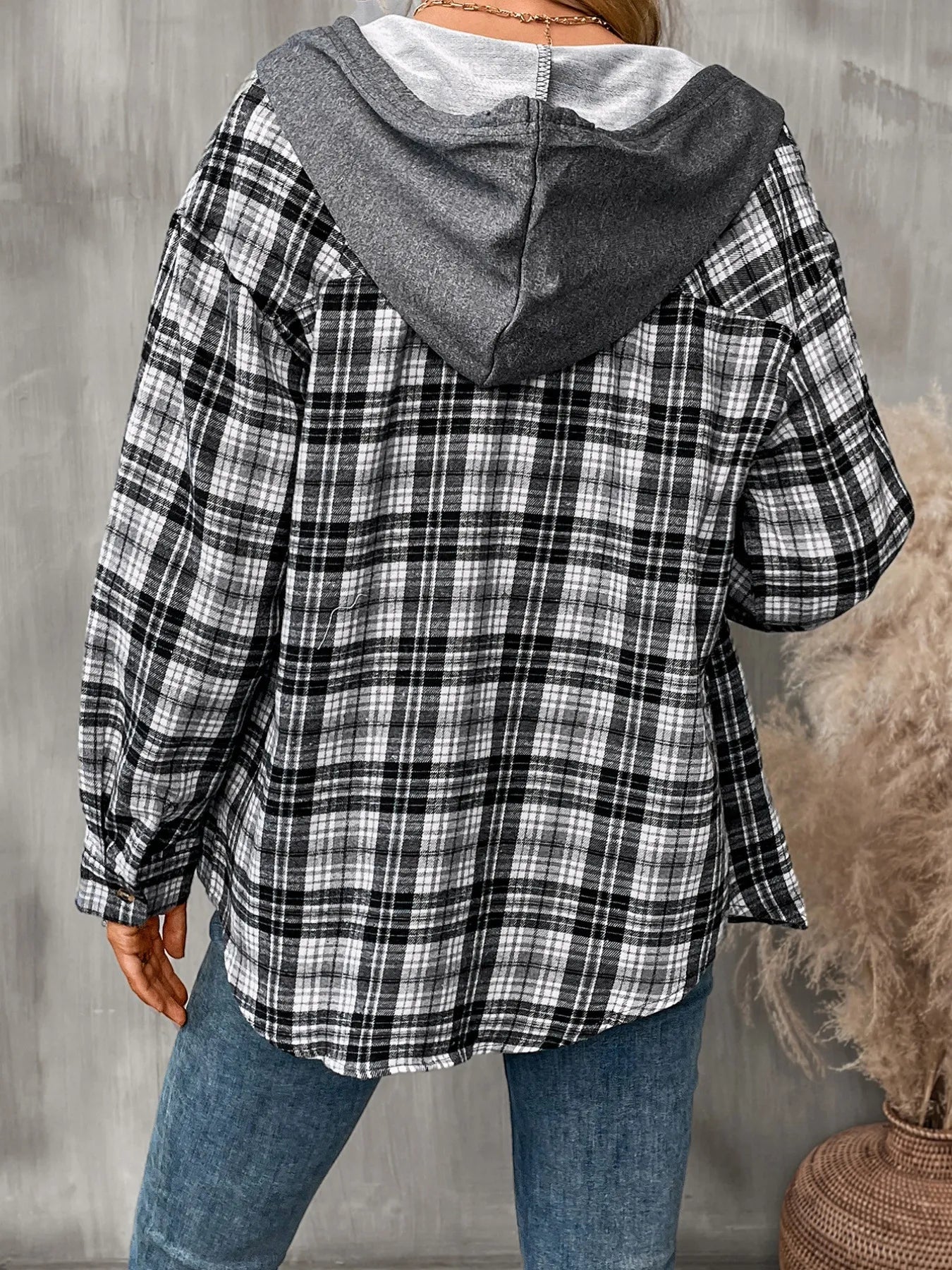 Black plaid hoodie shirt with button-front design and chest pocket, worn over a white tank and jeans for a chic casual style.