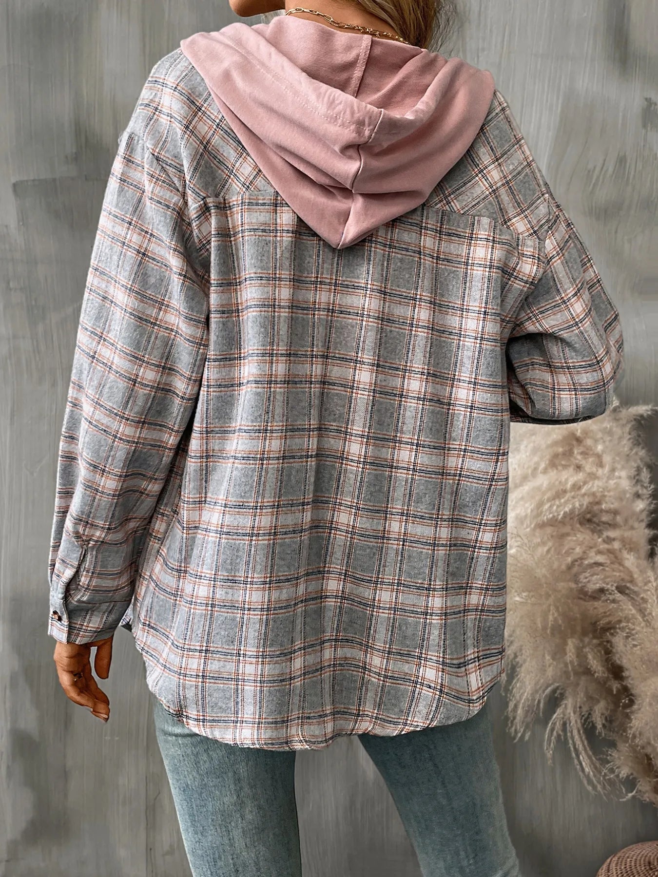 Woman in a grey plaid button-up hoodie shirt layered over a white tee, styled with denim for a minimalist cool-weather look.