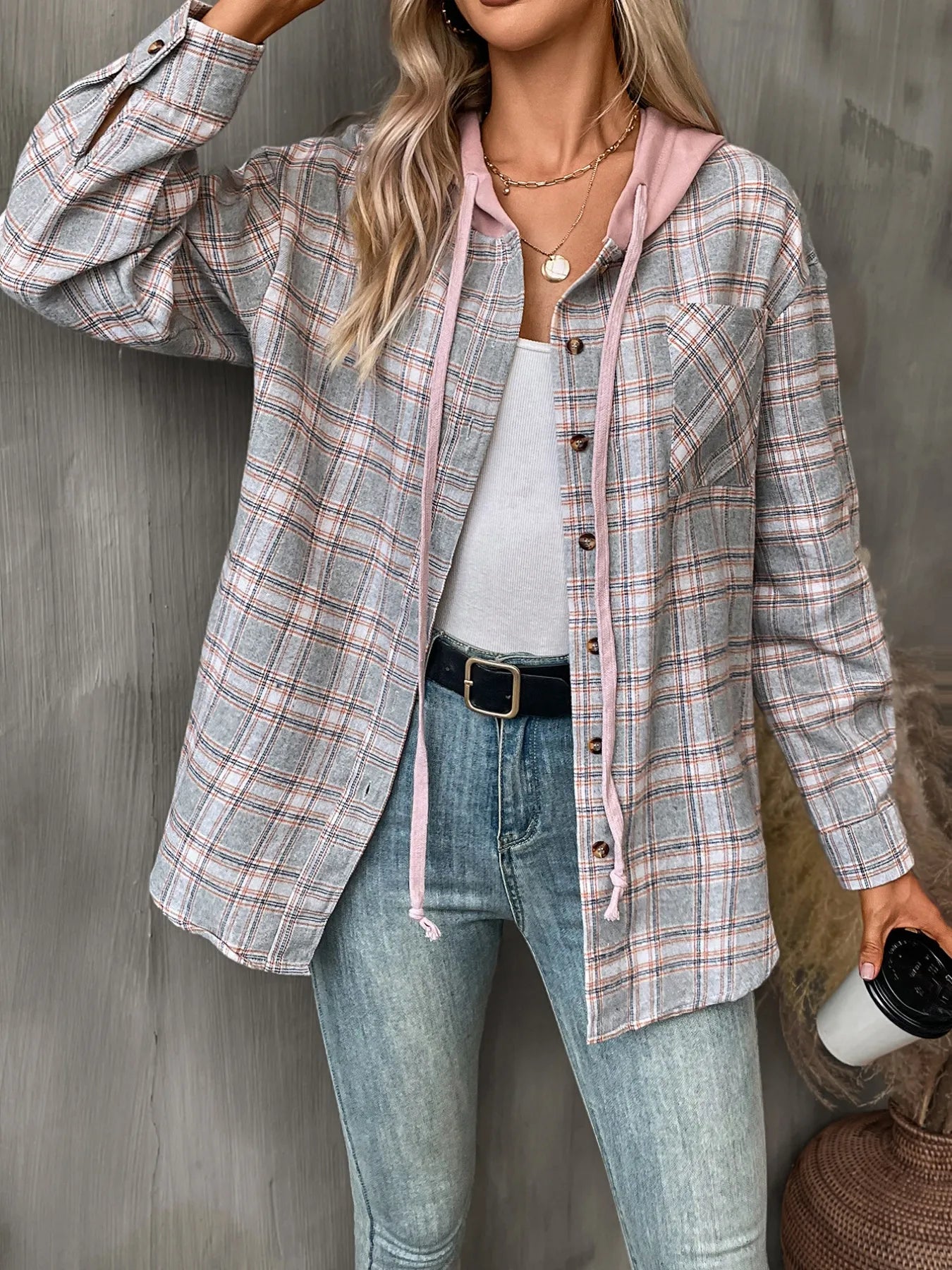 Woman in a grey plaid button-up hoodie shirt layered over a white tee, styled with denim for a minimalist cool-weather look.