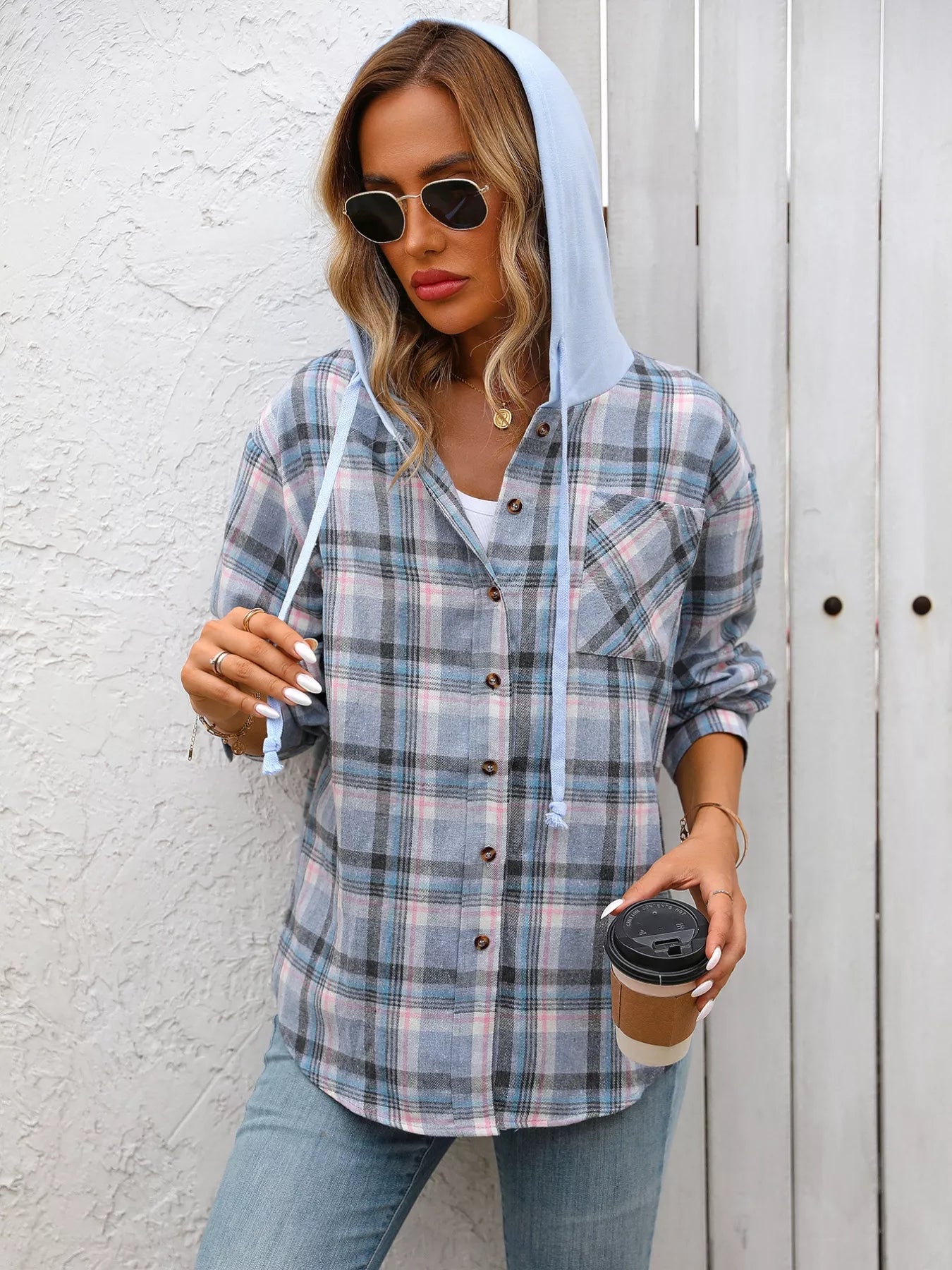 Woman in a light-blue plaid flannel hoodie shirt paired with denim jeans and a white top, creating a soft relaxed look for everyday wear.