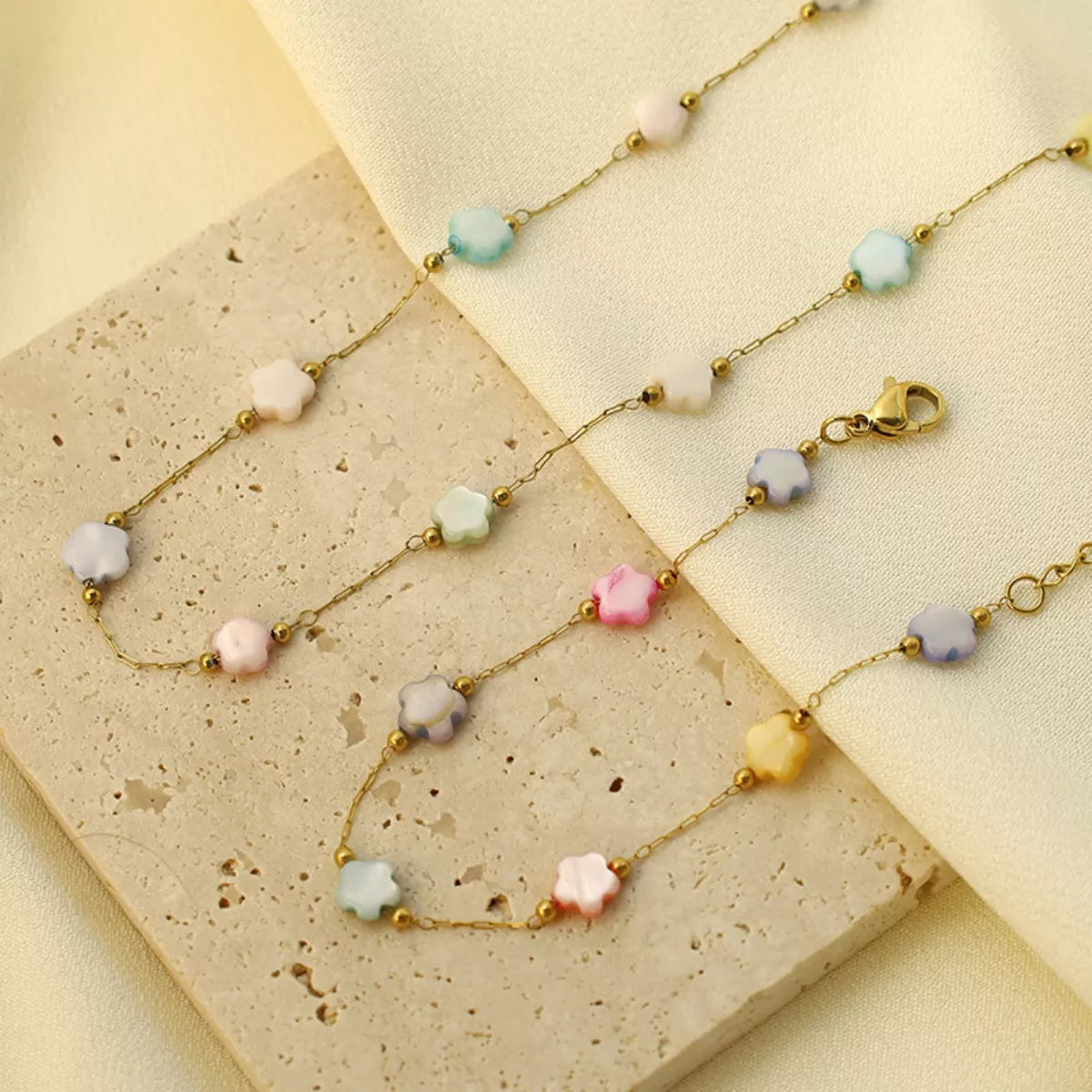 Delicate gold plated beaded chain necklace with soft resin beads displayed on a neutral fabric background