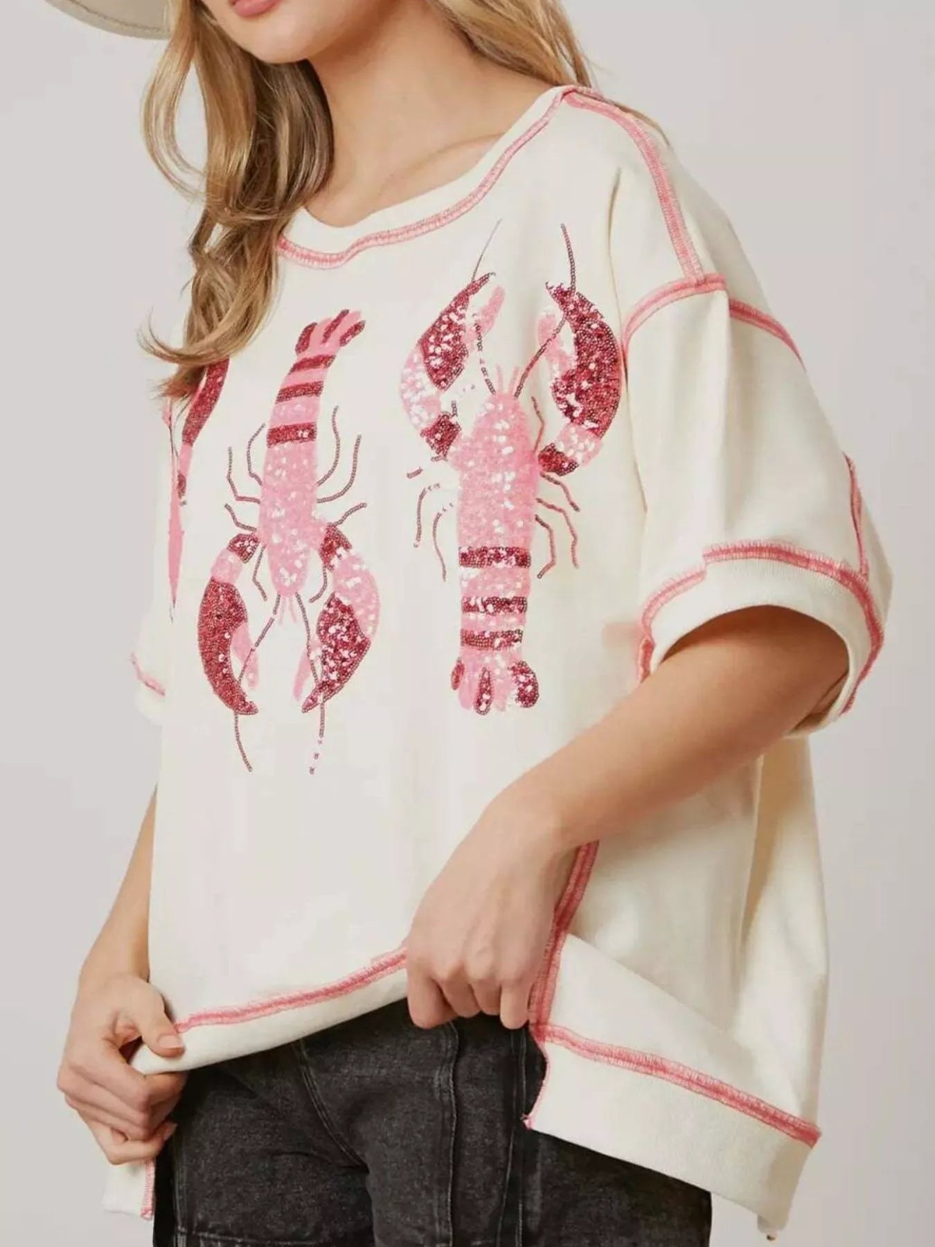 Oversized white tee with pink glitter lobster print and contrast stitching.