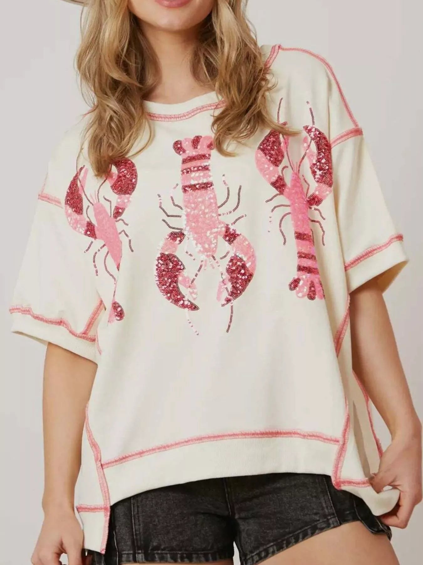 Oversized white tee with pink glitter lobster print and contrast stitching.