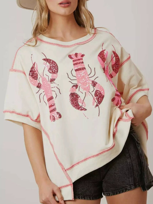 Oversized white tee with pink glitter lobster print and contrast stitching.