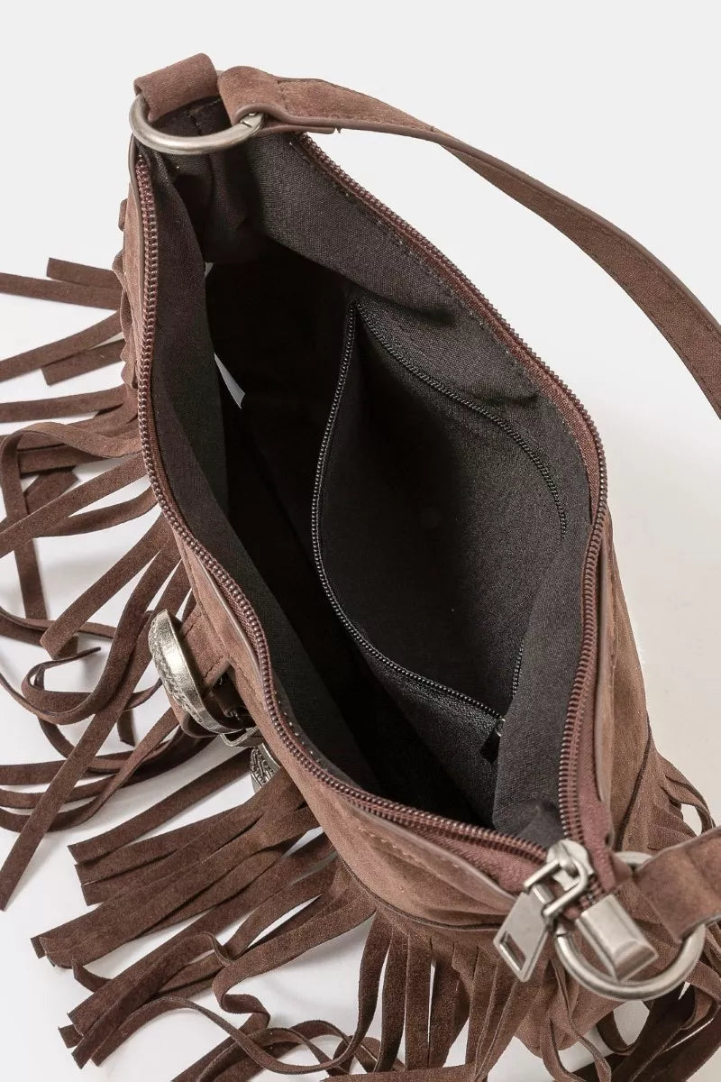 Brown faux suede shoulder bag with cascading fringe and vintage silver buckle detail, displayed with detachable strap — boho accessory from A Whimsical Affair.