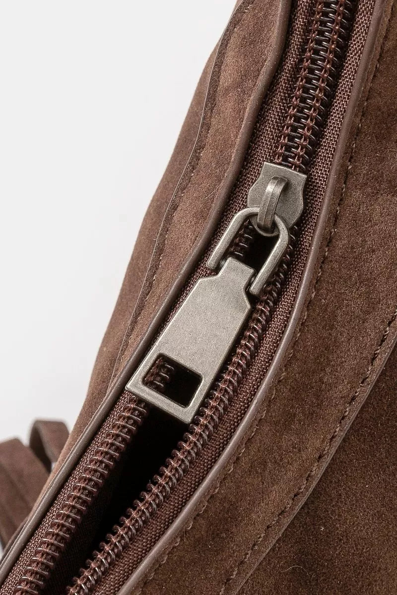 Brown faux suede shoulder bag with cascading fringe and vintage silver buckle detail, displayed with detachable strap — boho accessory from A Whimsical Affair.