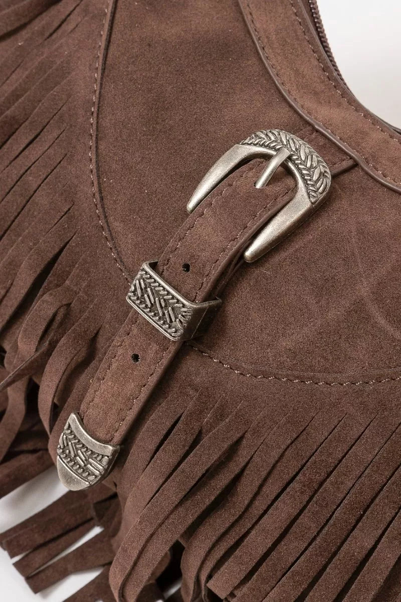 Brown faux suede shoulder bag with cascading fringe and vintage silver buckle detail, displayed with detachable strap — boho accessory from A Whimsical Affair.