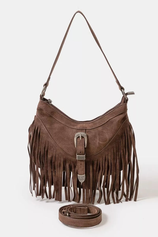 Brown faux suede shoulder bag with cascading fringe and vintage silver buckle detail, displayed with detachable strap — boho accessory from A Whimsical Affair.