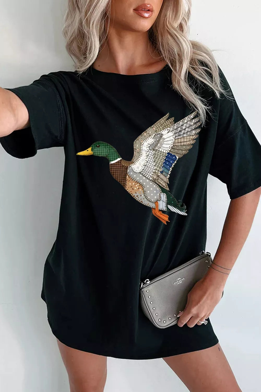 Black short sleeve graphic tee with a patchwork-style flying mallard duck design, relaxed fit, and slightly stretchy cotton-blend fabric.