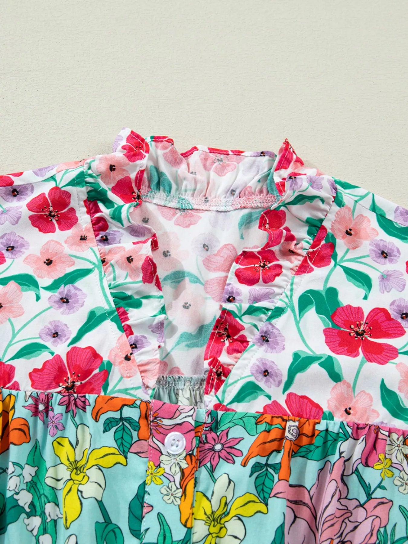 colorful floral boho blouse with ruffle sleeves and relaxed fit paired with distressed denim shorts