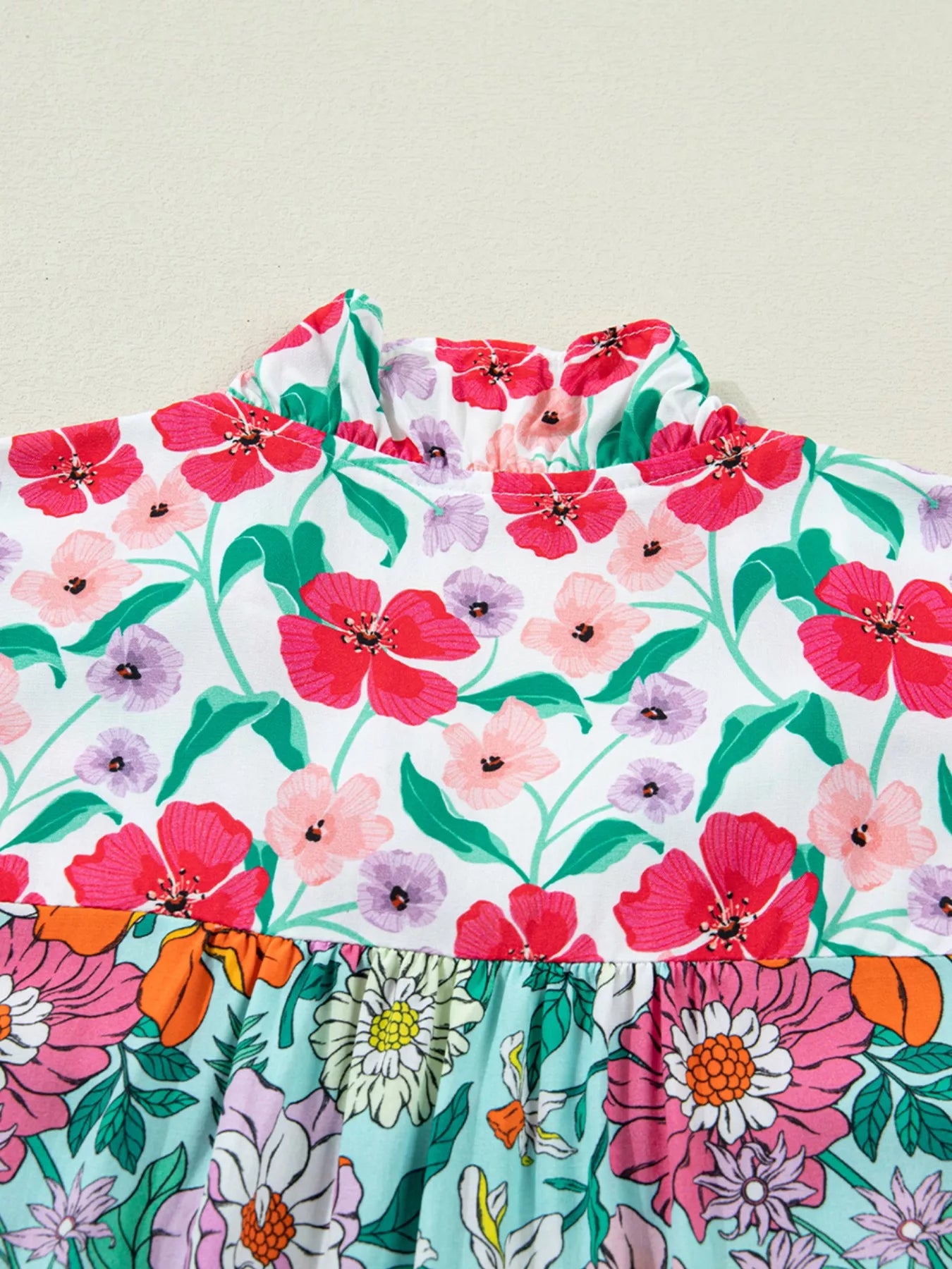 colorful floral boho blouse with ruffle sleeves and relaxed fit paired with distressed denim shorts