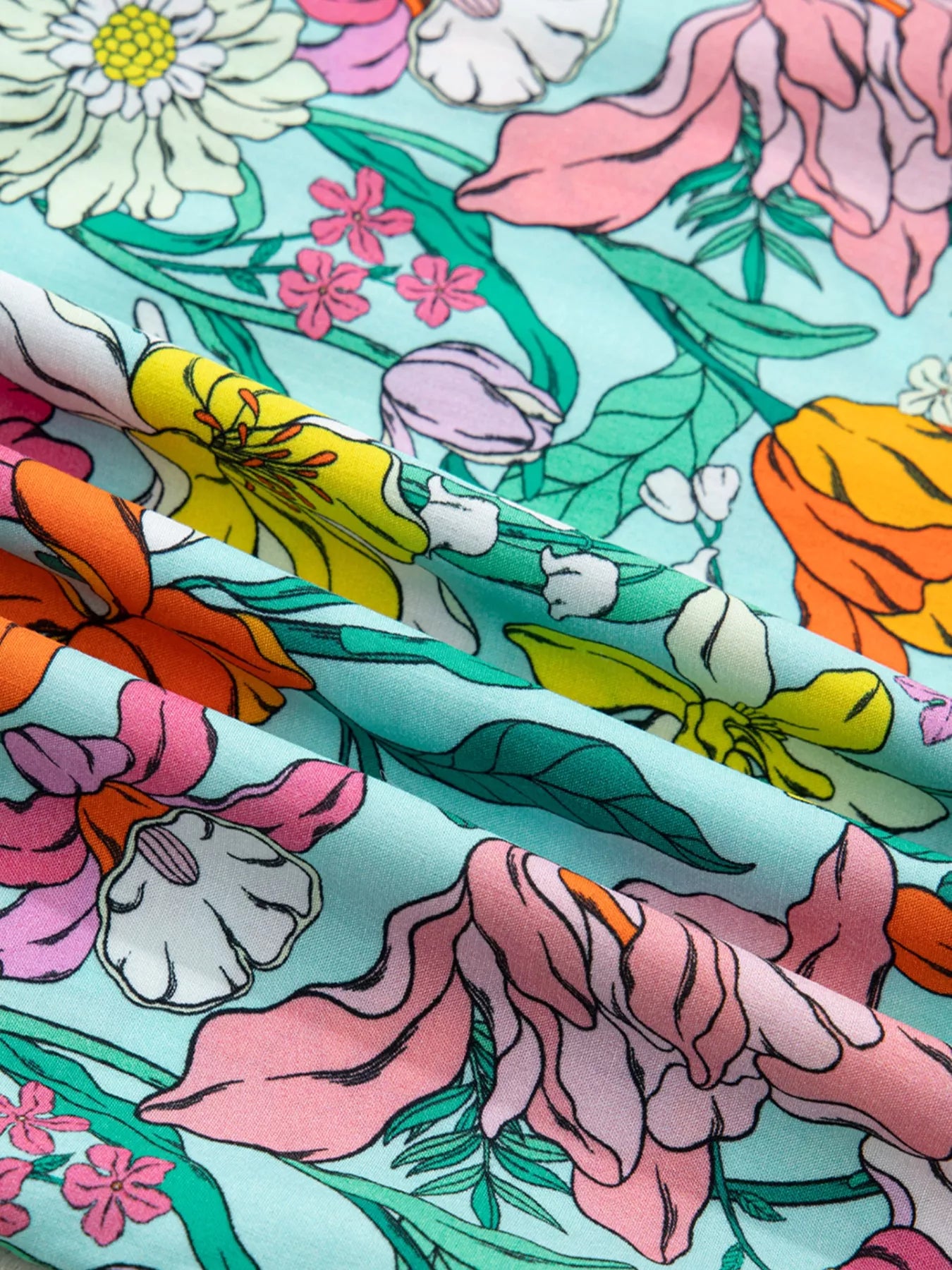 colorful floral boho blouse with ruffle sleeves and relaxed fit paired with distressed denim shorts