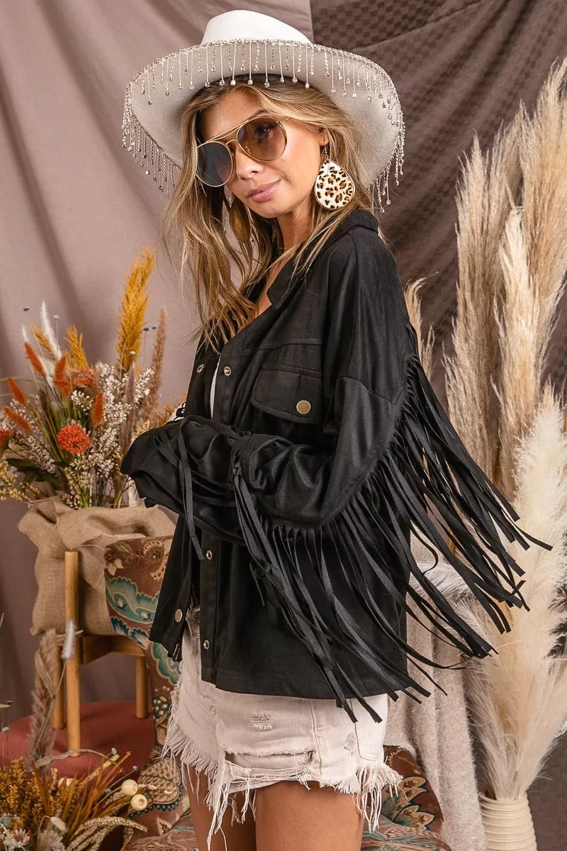 Woman wearing a suede-inspired black fringe jacket with button-up front and long sleeve boho Western style.