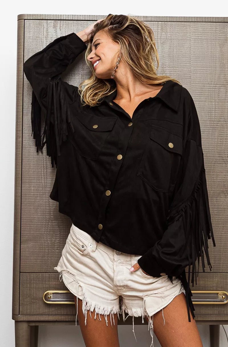 Woman wearing a suede-inspired black fringe jacket with button-up front and long sleeve boho Western style.
