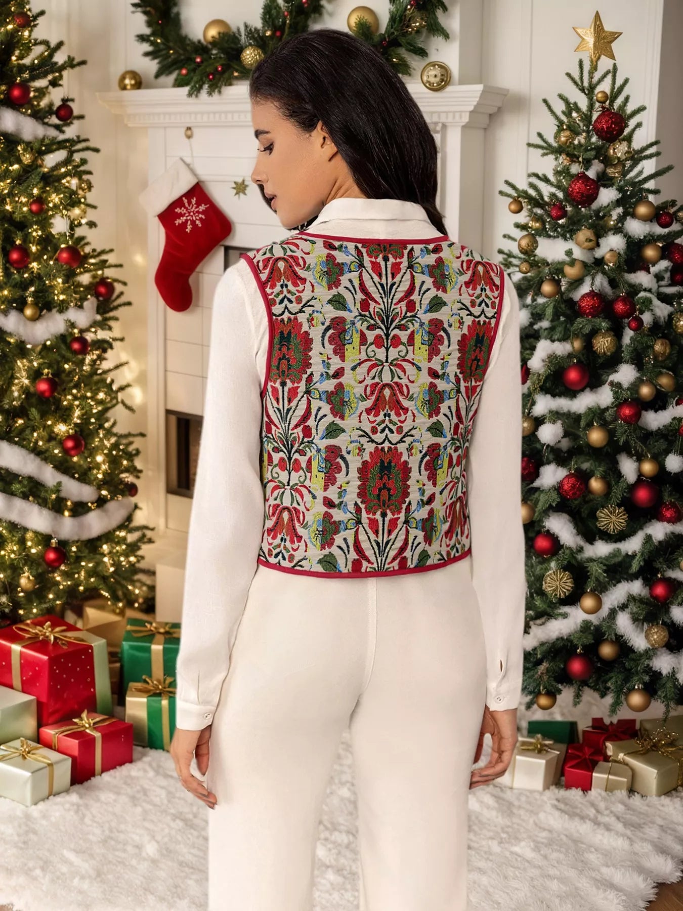 Embroidered floral tie-front vest layered over a white blouse, styled in a festive holiday setting with Christmas trees and presents.