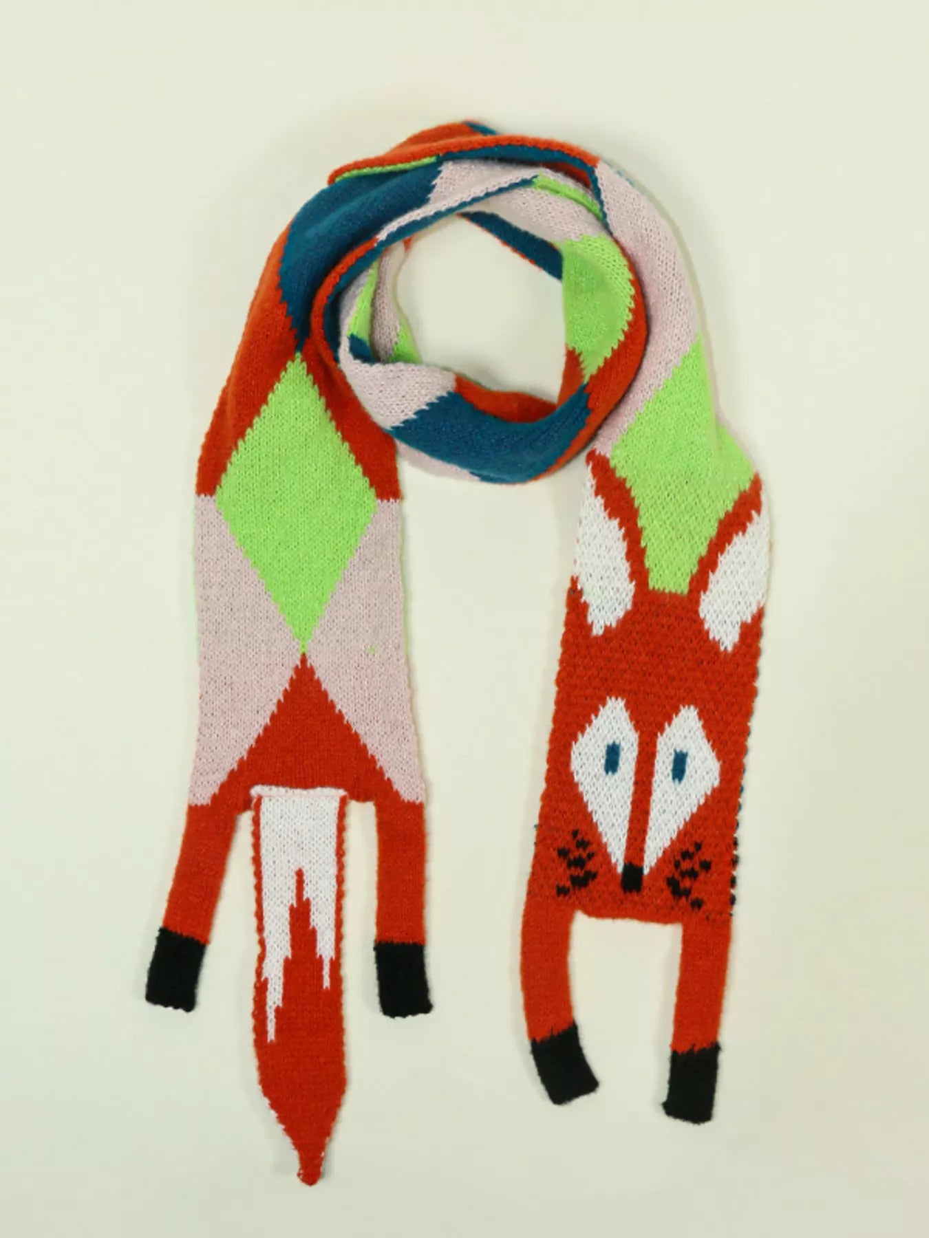 Whimsical knit fox scarf with soft texture and tapered ends hanging on a wooden branch.