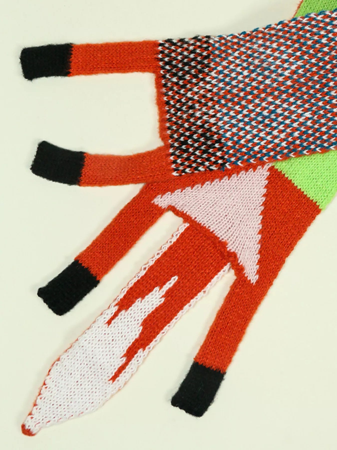 Whimsical knit fox scarf with soft texture and tapered ends hanging on a wooden branch.